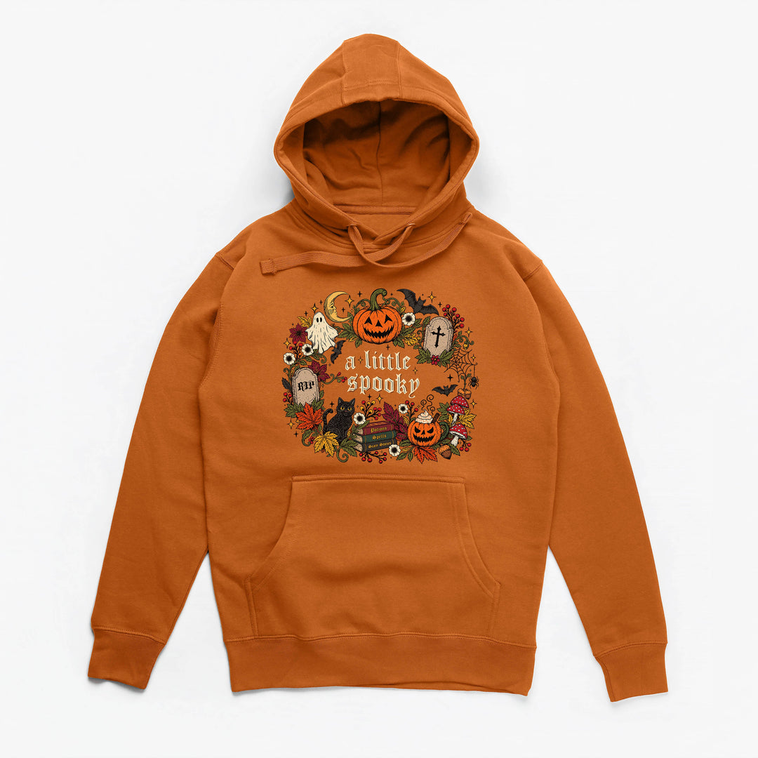 An orange pullover hoodie with a festive Halloween graphic on the chest that reads 'a little spooky' surrounded by pumpkins, ghosts, and autumn elements, displayed on a clean white background.